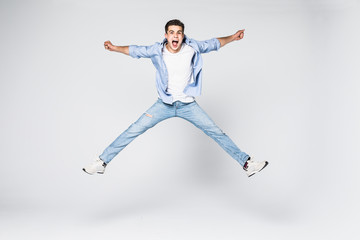 Smiling joyful man jumping on white background.