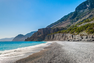 Crystal clear blue waters with fine pebbles in Domata beach at Sfakia in Crete, Greece. The beach...