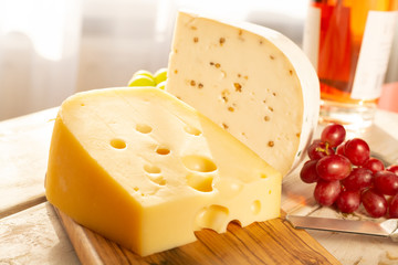 Dutch hard cheese Maasdam or Emmentaler, cheese with holes and white hard goat cheese with coriander