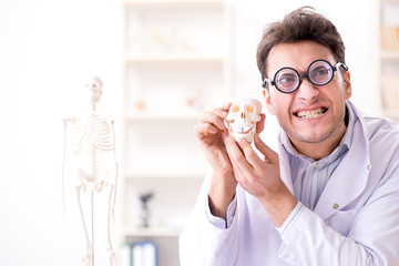 Obraz na płótnie Canvas Crazy doctor studying human skeleton