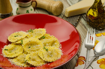 Ravioli with tomato and ricotta cheese. Parmesan grated over a plate with ravioli 