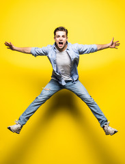 Fototapeta na wymiar Young handsome man jumping on yellow background. Jump, freedom, summer.