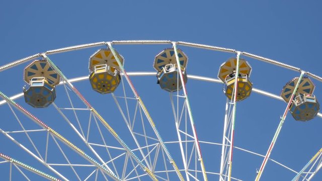Big ferris wheel in the amusement park. Blue sky in the background.