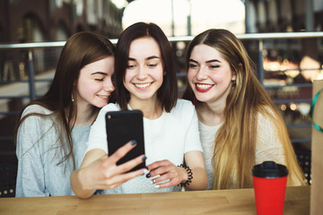 Three young women have fun and take selfie together