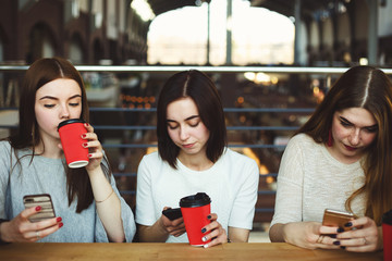 Women sitting at cafe engrossed in reading networks