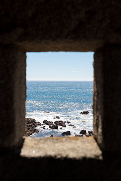 Rocks and ocean framed by a fortress window