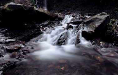 Waterfall at the carpatian mountains at the green rainy pine forest