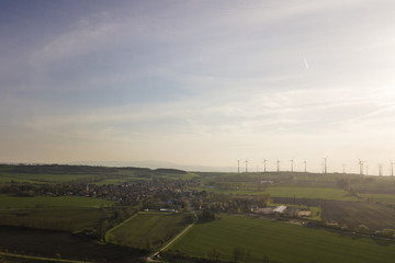 View over Badersleben, windmills, fields and forest in spring ( Huy, Harz mountians / Germany ) from above