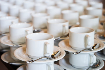 Set of Empty white ceramic tea or coffee cup and saucers, top view. Group of empty cups stacked in rows for serving coffee in restaurant