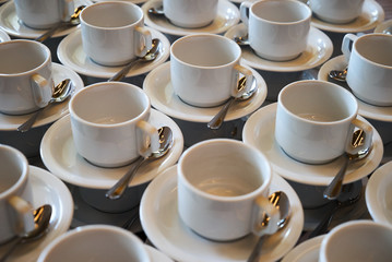 Set of Empty white ceramic tea or coffee cup and saucers. Group of empty cups stacked in rows for serving coffee in restaurant