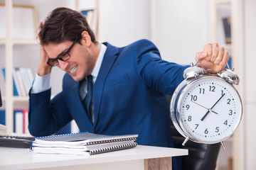 Businessman employee in urgency and deadline concept with alarm 