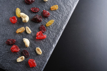 Obraz na płótnie Canvas nuts dried fruits on a dark stone background