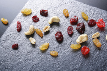 nuts dried fruits on a dark stone background