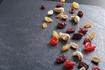 nuts dried fruits on a dark stone background