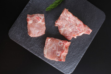 pieces of meat boneon a dark stone background