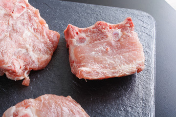 pieces of meat boneon a dark stone background