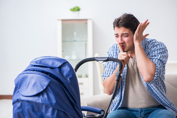 Young father looking after newborn baby at home