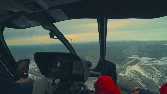 Helicopter cockpit flying on mountain landscape and cloudy sky