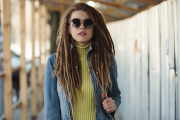 Stylish woman with dreadlocks, fashion portrait in city