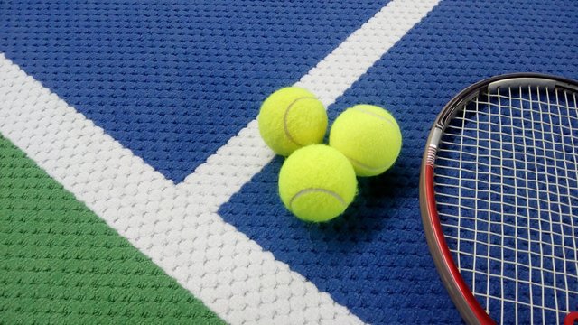Tennisschläger mit Tennisbällen auf einem Indoor Tennisplatz