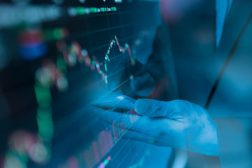 Double exposure Businessman finger touching smart phone with finance and banking profit graph of stock market trade indicator financial