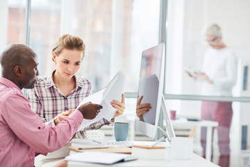 Business couple sitting at office and reading business contract together