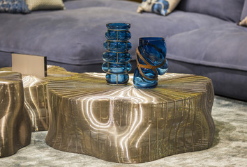 Blue fashionable glass vases on the gold modern table. Stylish interior art deco