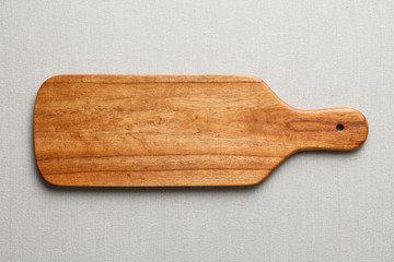 Handmade wooden cutting board on the linen