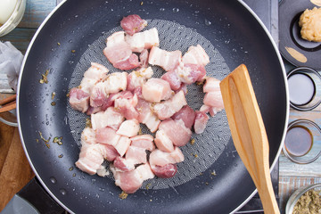 Chef stirfry streaky pork in pan