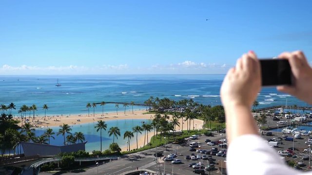 Professional video of woman taking picture of Waikiki beach in Hawaii in slow motion 180fps