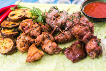 shish kebabs with vegetables and herbs on a pita bread sheet