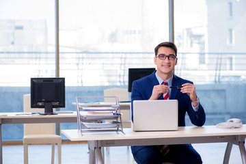 Young handsome businessman employee working in office at desk