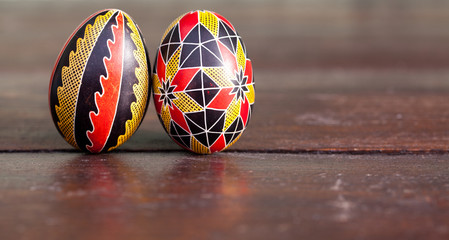 white organic eggs in tray and traditional painted easter eggs from Bucovina region, Romania