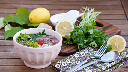 Pho soup -  Vietnamese noodle soup with broth, linguine-shaped rice noodles, cilantro and beef