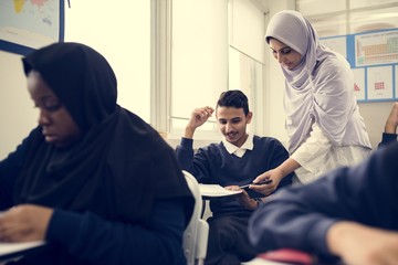 diverse muslim children studying in classroom