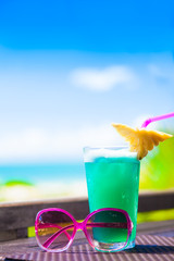 picture of a delicious cocktail and sunglasses on tropical beach