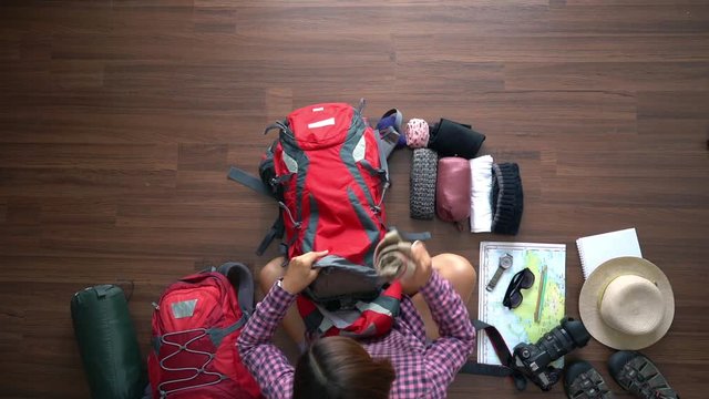 Overhead view of traveler woman plan and backpack travel planning vacation trip. Top view slow motion