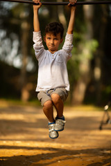 Boy performing pull-ups on bar during obstacle course in boot camp