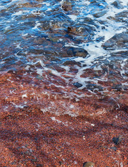 closeup of red sand on the coast at hana maui hawaii