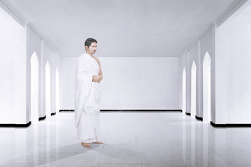 Photo of asian muslim man with ihram cloth praying