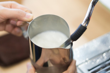 Fototapeta na wymiar Closeup stream milk for make hot coffee latte art with machine, selective and soft focus
