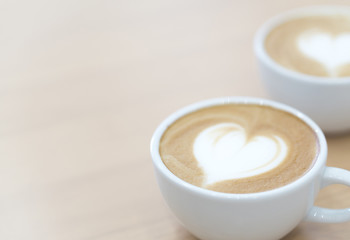 Closeup latte art coffee with heart shape in white cup for relax time and holiday concept,...