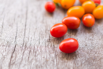 Fresh cherry tomatoes on wood background, raw food and vegetable, selective focus