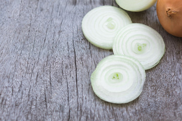 Fototapeta na wymiar Closeup onion sliced on wood background, food ingredient concept, selective focus