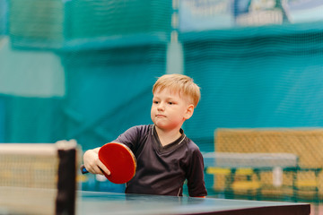 boy playing table tennis in the tennis hall