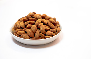 Almond milk in glass with almonds on white background