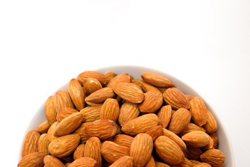 Almond milk in glass with almonds on white background