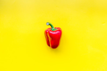 Red sweet bell pepper on yellow background top view copy space