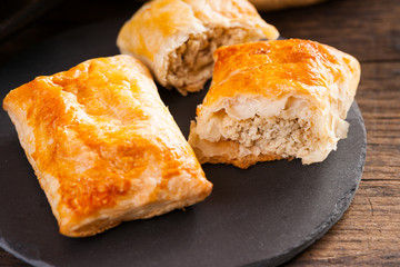 Pie made from puff pastry with meat on plate