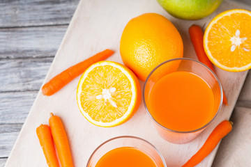 Glasses with carrot juice, apple and sliced orange  